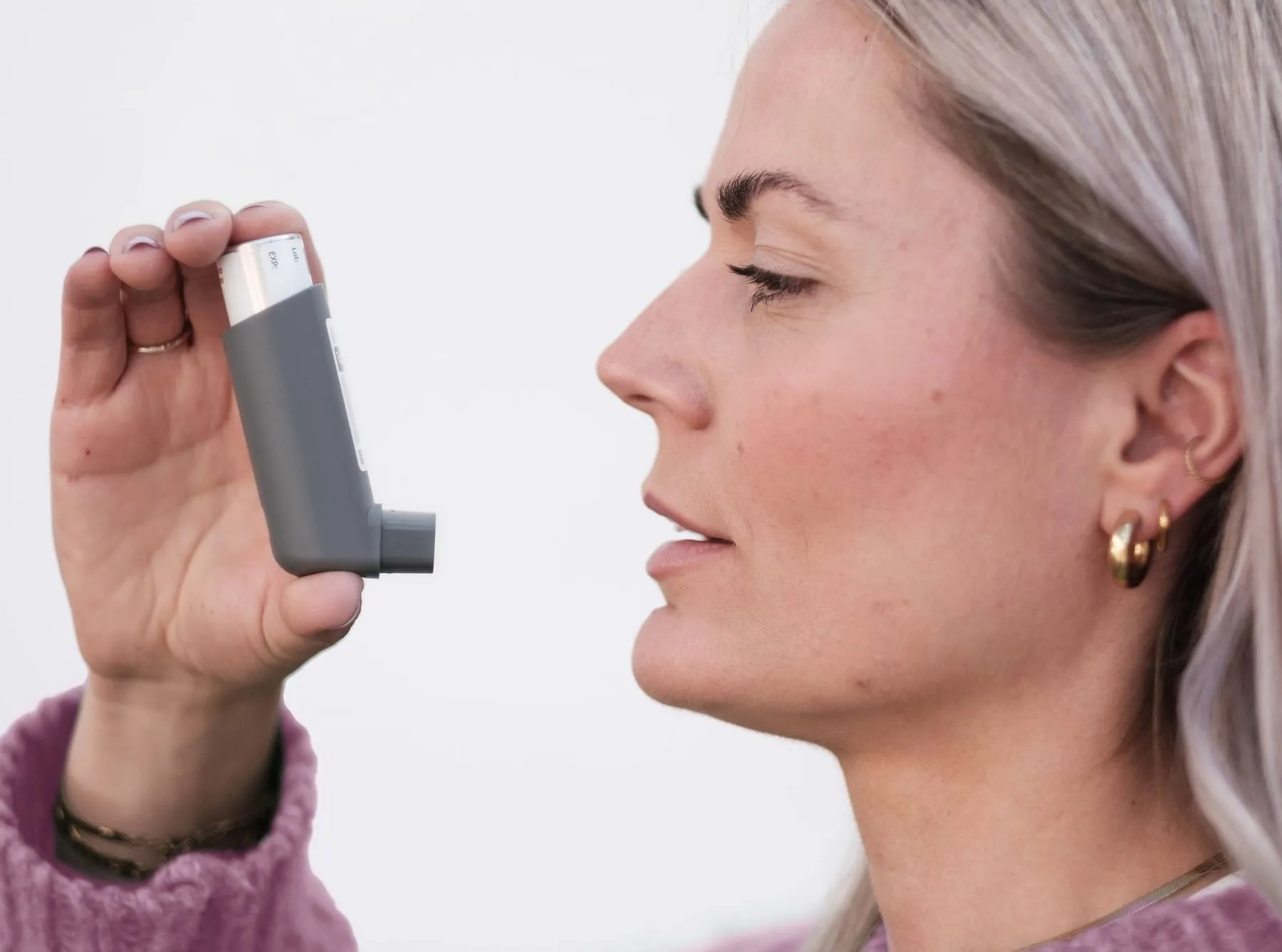 A woman holding an asthma inhaler