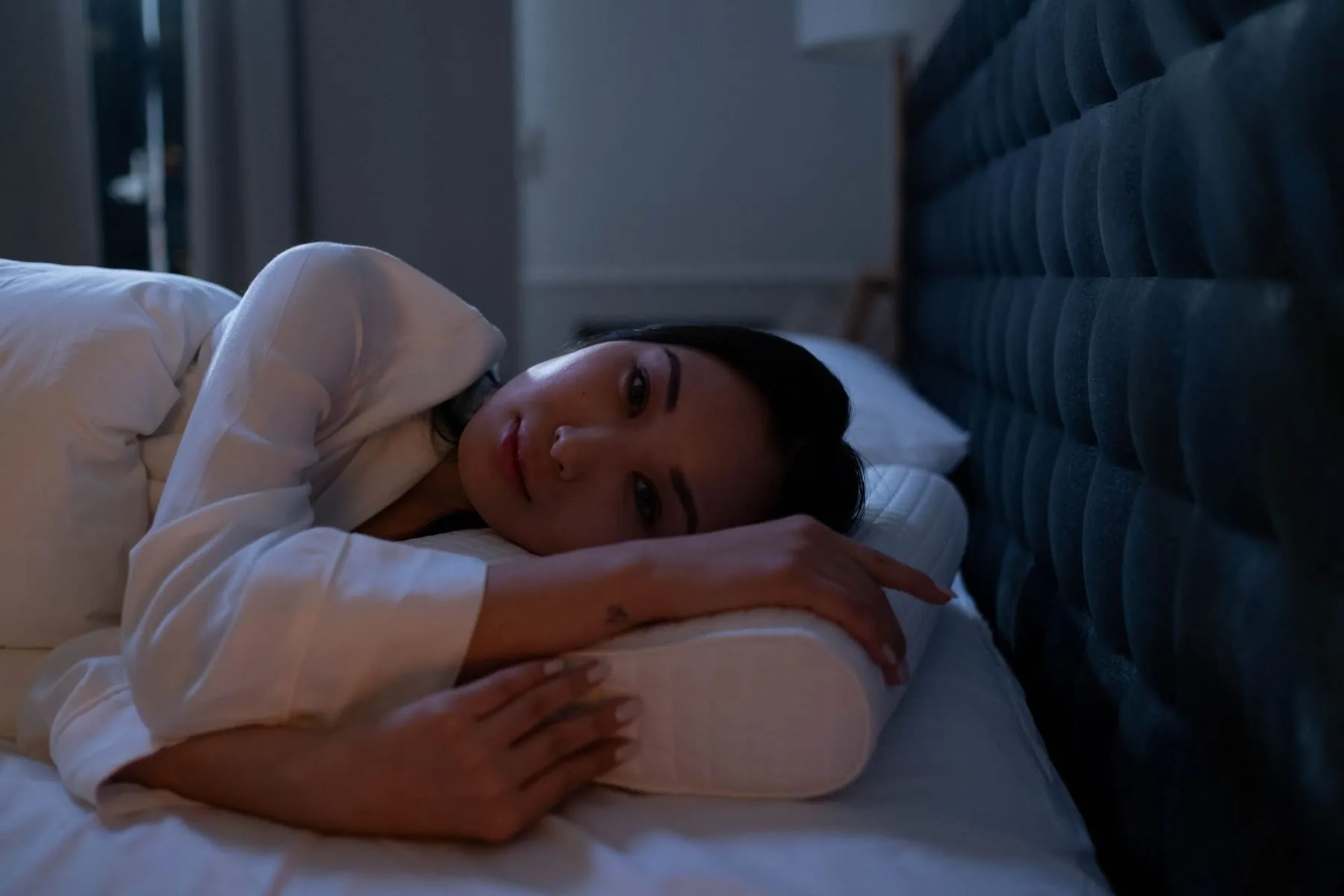 A woman lying awake in bed at night